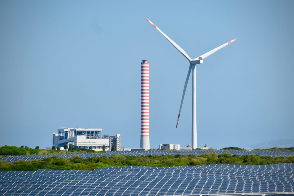 Aerogenerador al lado de un campo de placas solares